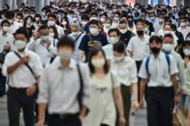 マスク装着が欠かせなくなった朝の通勤風景(AFP=時事通信フォト)