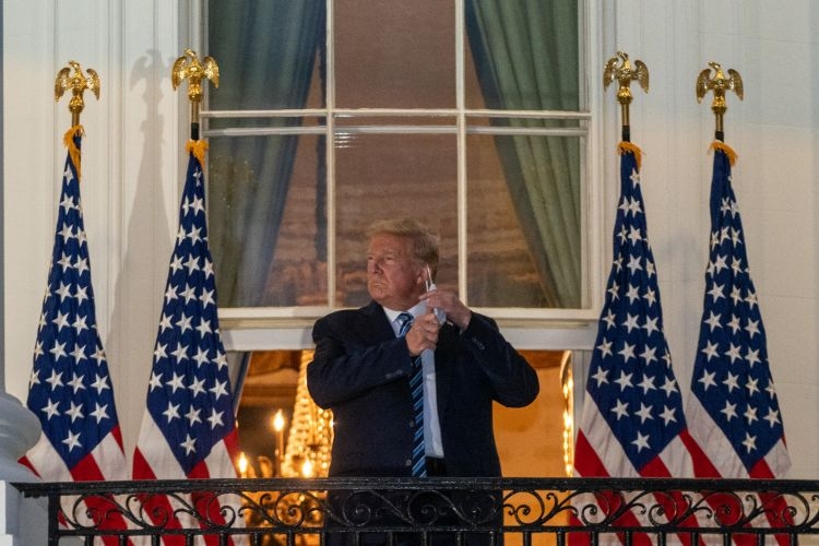 夕暮れ時、ホワイトハウスのバルコニーに立ちマスクを外すトランプ氏（写真／Sipa USA/時事通信フォト）