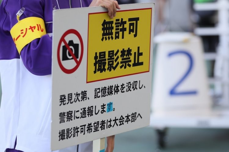 木南道孝記念陸上競技大会では、会場でスタッフが手に持つ無許可での撮影禁止を示す看板を掲げていた（時事通信フォト）