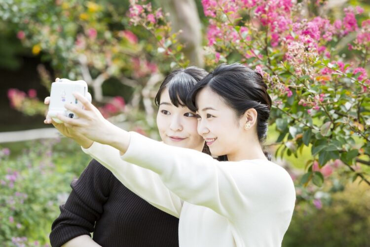 チェキで自撮りをされる眞子さまと佳子さま（10月6日。東京・港区　写真／宮内庁提供）