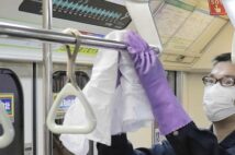 3月の札幌市、アルコール消毒液で地下鉄車両のつり革などを拭く清掃業者(時事通信フォト)