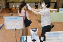 ホテルロビーでの検温も当たり前の光景に(時事通信フォト)