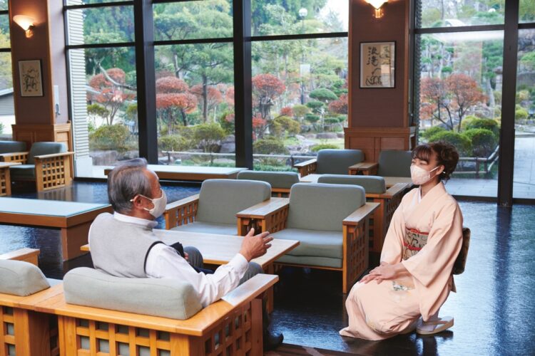 庭園を眺められるロビーラウンジで宿泊客と歓談する永山さん。女将の姿を見かけると、客から声をかけるなど人気ぶりがうかがえる