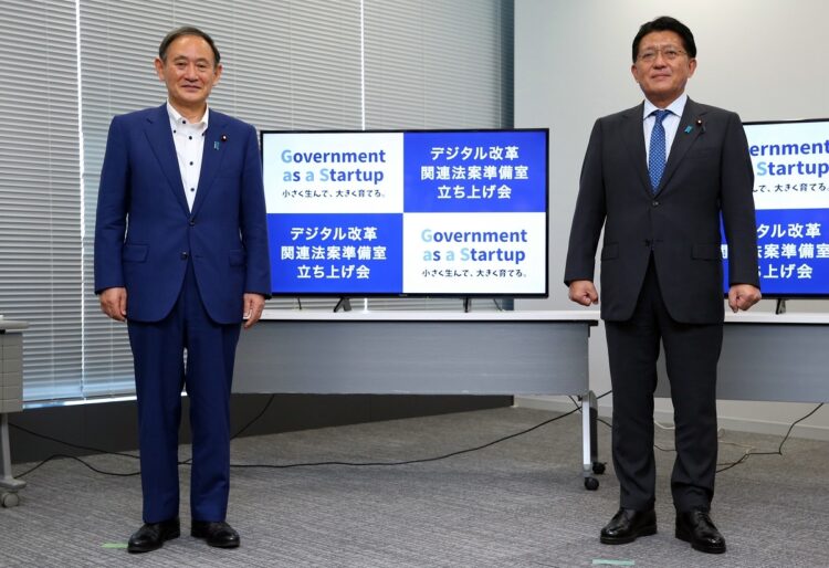 菅義偉首相（左）と平井卓也デジタル改革担当相。行政のDX（デジタル・トランスフォーメーション）を推進するのがデジタル庁（時事通信フォト）