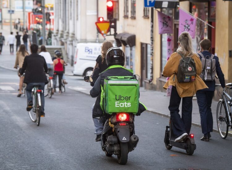 フードデリバリー中のバイク、自転車、電動キックスケーターが併走するスウェーデン・ストックホルム（EPA＝時事）