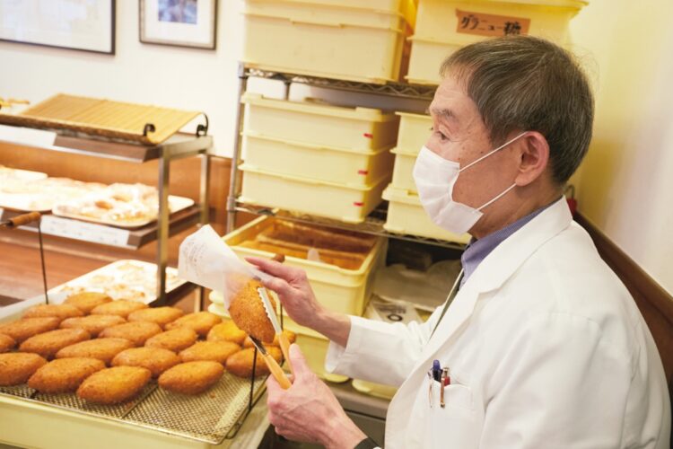 出来たてのカレーパンを店頭で販売する、5代目オーナーの中田さんのところには、カレーパンが店頭に並ぶのを待っていた客がひっきりなしにやってくる