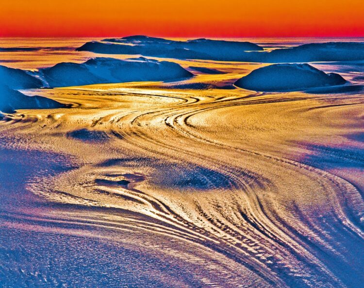 夕陽のスケルトン氷河（南極）。南極大陸一周に成功した際に撮影。南極点の下に広がるロス棚氷、その右下隅にあるスケルトン氷河が夕陽を浴びて色鮮やかになった瞬間を捉えた1枚