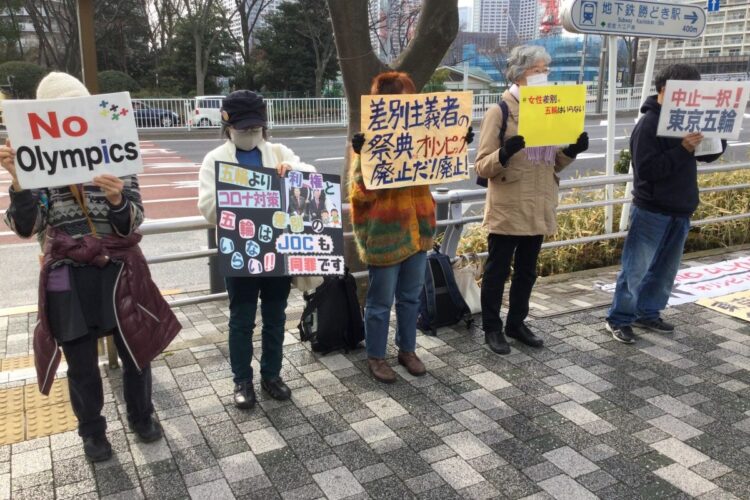 五輪組織委員会の事務局近くで五輪反対の声を上げる市民団体メンバー（時事通信フォト）