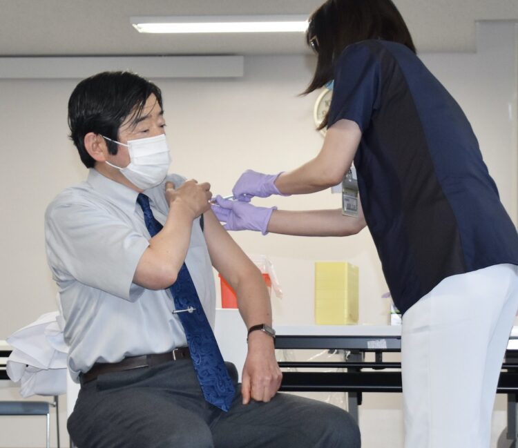 新型コロナウイルスのワクチン接種を受ける千葉労災病院の岡本美孝院長（左）＝2月17日午後、千葉県市原市