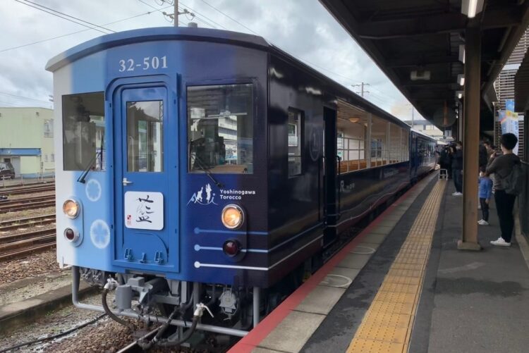 JR四国の観光列車「藍よしのがわトロッコ」。外観は特産の「阿波藍」をモチーフとし、2両編成のうち1両がトロッコ仕様。地元の食材を使った駅弁(要予約)を食べることもできる(時事通信フォト)