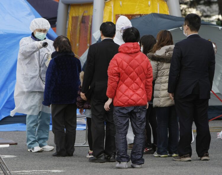 ガイガーカウンターを使ったスクリーニングの様子(時事通信フォト)