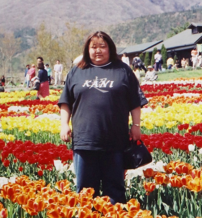 咲き乱れる花を背景に。黒いTシャツ姿の赤堀容疑者