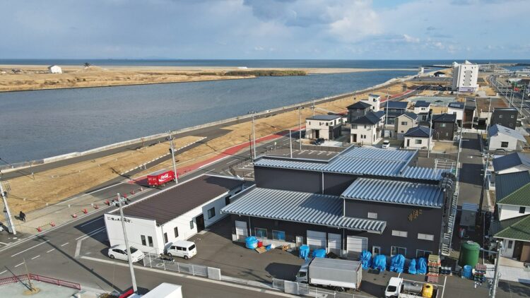 創業の地で復興(手前白と黒の建物)。目の前を名取川が流れ、河口の先に太平洋が広がる