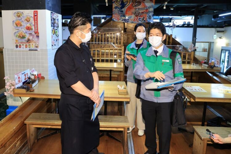「まん防」の適用が始まり、飲食店の感染防止対策を点検する東京都の職員（新宿区／時事通信フォト）