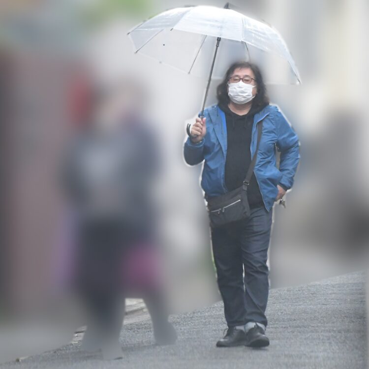 傘をさす高内氏