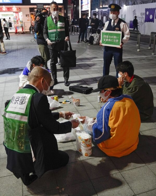 3度目の緊急事態宣言の発令前日、路上で飲酒する若者らに新型コロナウイルス感染拡大防止の協力を呼び掛ける東京都の職員ら(EPA=時事)