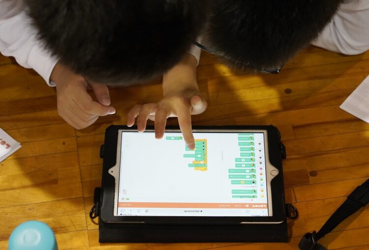 2020年度から必修化されたプログラミングをする小学生。操作に使うのはタブレット（イメージ、時事通信フォト）