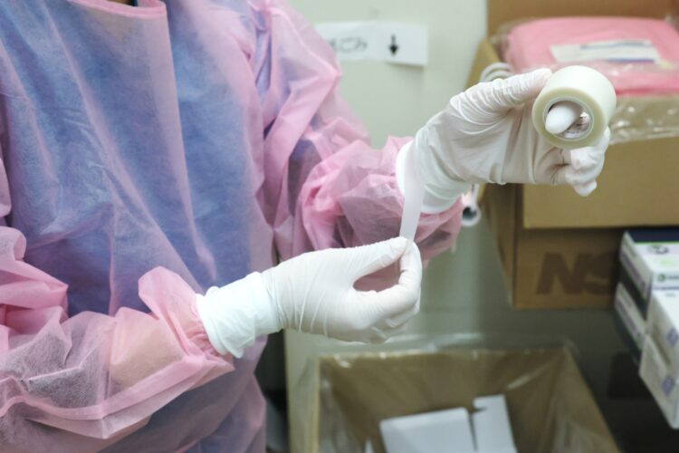 ウイルスの侵入を防ぐため、ゴム手袋は二重に装着し、内手袋は手首部分をテープでしっかり密閉する。外手袋とエプロンは病室を移動するたびに新しいものに交換する