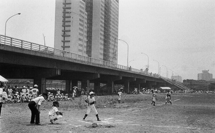 1970年撮影。開発予定地で行なわれた野球大会。道路の先に開業前の京王プラザホテルが見える（写真／新宿区立新宿歴史博物館）