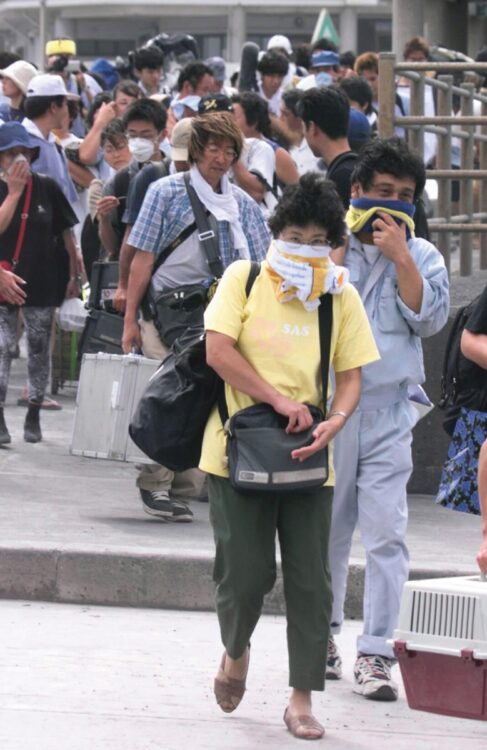 2000年の三宅島噴火で火山灰対策をして避難する住民（時事通信フォト）