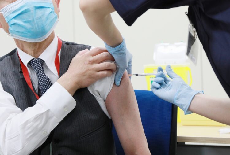 厚労省は新型コロナワクチンの接種に関わる症状の報告を義務づけている（時事通信フォト）