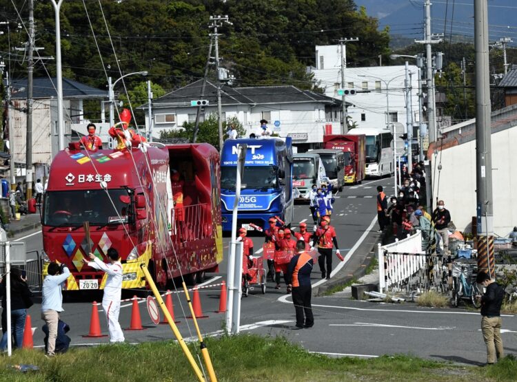 聖火と共に五輪スポンサー企業の車が通る様子