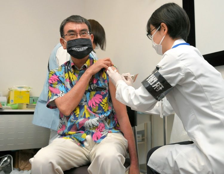 カラフルなバナナ柄のシャツを着てワクチンを接種する河野氏（写真／時事通信フォト）