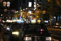 新型コロナウイルス感染拡大の影響で閑散とした歓楽街で行列を作る客待ちのタクシー(イメージ、時事通信フォト)