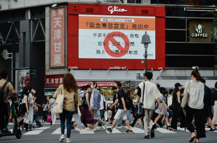 緊急事態宣言が発令される中、渋谷のスクランブル交差点を行き交う人々（イメージ、時事通信フォト）