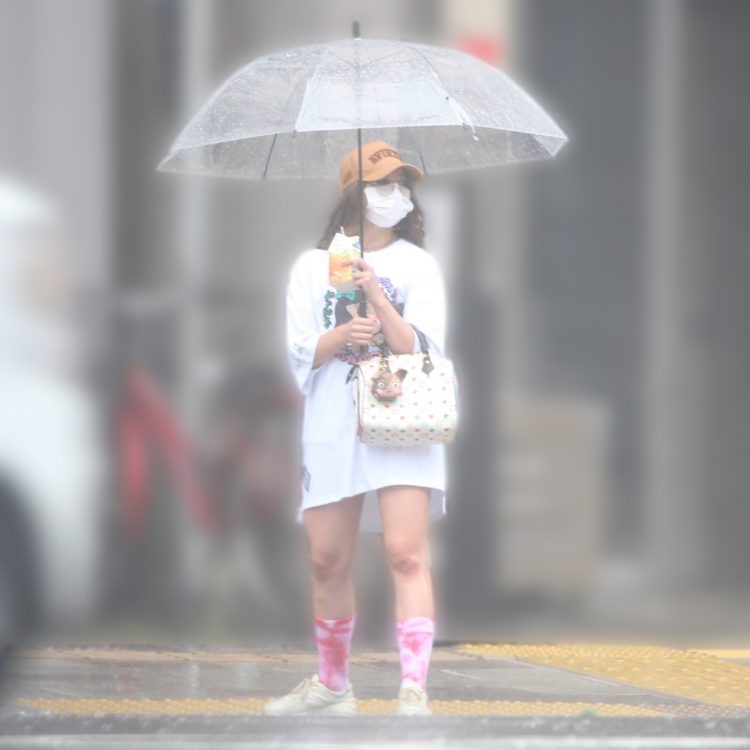 雨のなか、白のビッグサイズのTシャツ姿で立つゆきぽよ