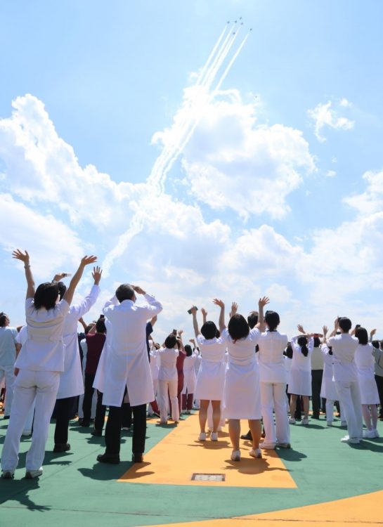 2020年5月29日、新型コロナウイルス感染症患者の治療などに当たる医療従事者に感謝と敬意を伝えるため、白いスモークを引いて東京都心上空を飛行するブルーインパルス（時事通信フォト）