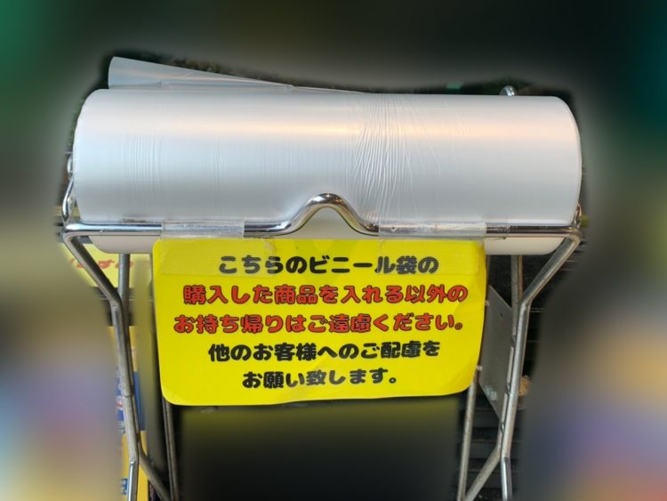 〈こちらのビニール袋の購入した商品を入れる以外のお持ち帰りはご遠慮ください〉という貼り紙が