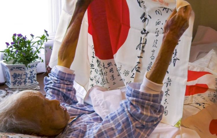 出征旗を見つめる外山さん。戦争体験を語ることも多かった