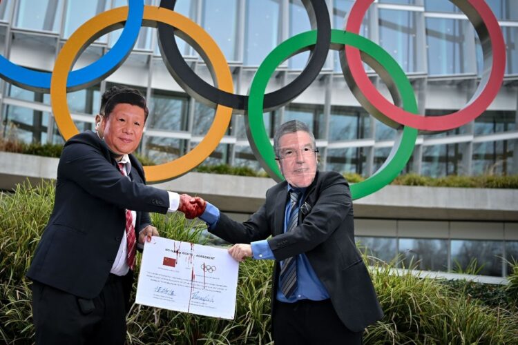 スイスで行われた北京五輪反対のパフォーマンス。習近平とトーマス・バッハIOC会長の「ガッチリ握手」は悪者感たっぷり(AFP=時事)