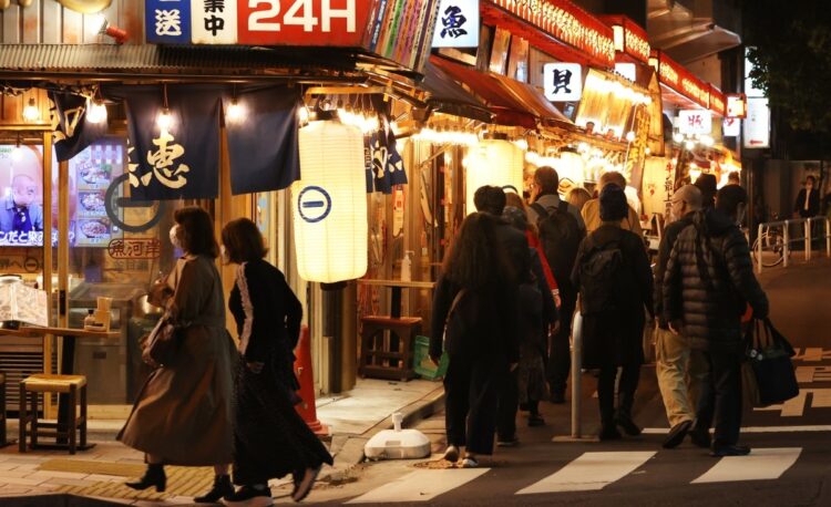 飲食店への営業時間の短縮要請が全面的に解除され、夜を迎えた東京・有楽町の飲食店街を歩く人たち＝10月25日午後、東京都千代田区（時事通信フォト）