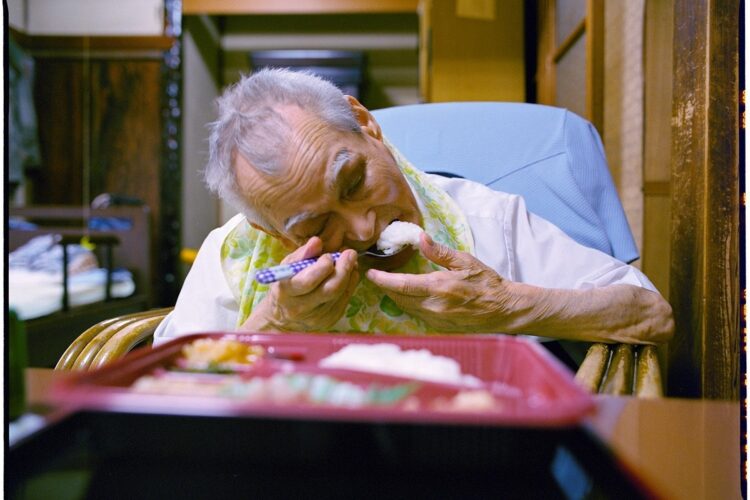 10年間、独り暮らしの老人に弁当を届けた福島あつしさんの写真が話題を呼んでいる（『ぼくは独り暮らしの老人の家に弁当を運ぶ』より）