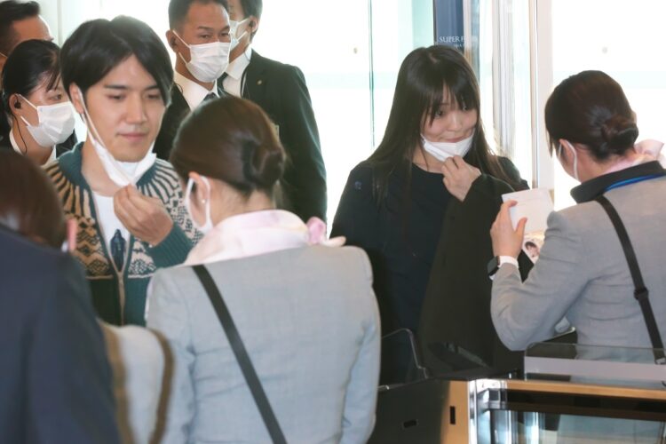 羽田空港、ゲート通過時には日本のマスコミから居合わせた旅行者などに見守られながら、マスクを外して顔を見せた