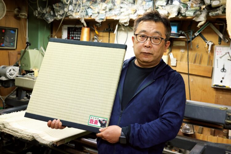 『007』最新作用に作った畳のサンプルを手にする森田さん
