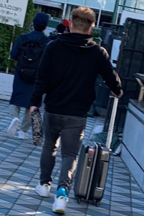 スーツケースを引いて移動する大下