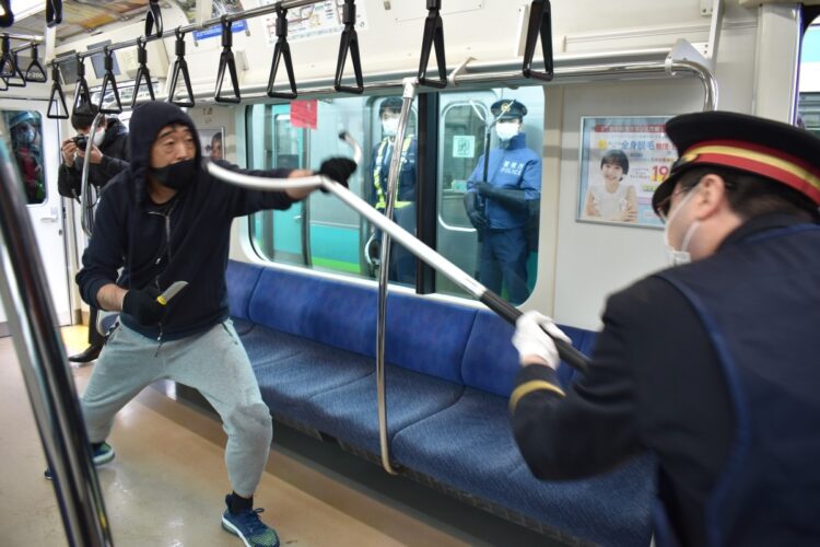 札幌の事件では容疑者の動きを封じるなど「さすまた」効果が明らかに。写真は2021年12月に実施された亀有署とJR東日本が実施した訓練。警察官が駅員らにさすまたの使い方などを指導した(時事通信フォト)