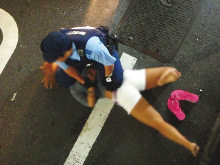 泥酔した女性を取り押さえる警察官（撮影／清平はじめ）