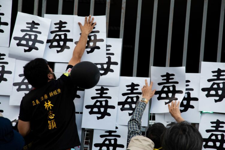 与党本部に「毒」の文字を貼り付ける、輸入再開に反対する人たち（写真／Getty Images）