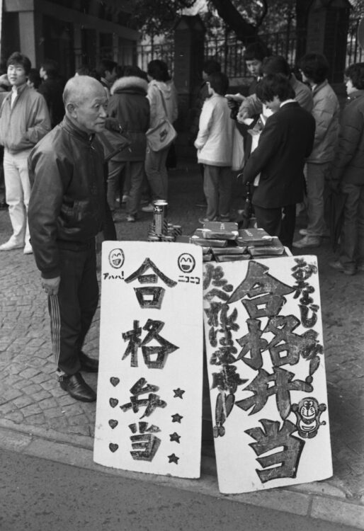 1982年、国公立大学共通一次試験が行われている東京大学前で「合格弁当」を売る弁当屋（時事通信フォト）