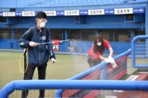 「夏季東西東京都高等学校野球大会」の試合間に、新型コロナウイルス感染防止のため、ベンチを消毒する球場スタッフ。2020年7月（時事通信フォト）