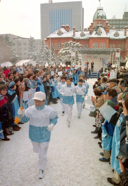 1998年1月6日、長野五輪の聖火ランナーの札幌第1走者として赤れんが庁舎前をスタートする金野昭次。第3走者はゴルファーの青木功だった(写真/共同通信社)