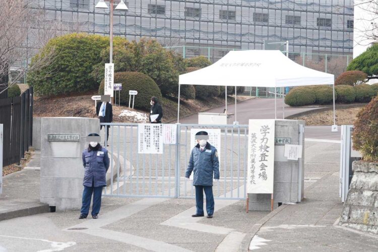 筑波大学附属中学・高校の正門前には警備員や、会場スタッフらの姿が。奥に見える校舎の外壁には足場が組まれている