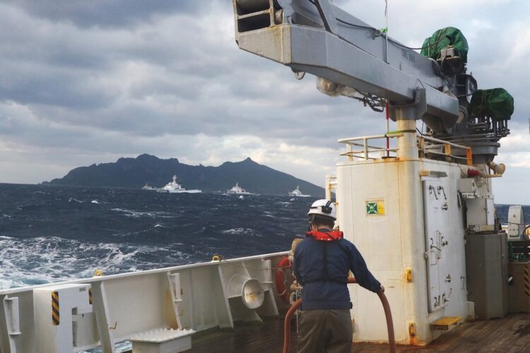 沖縄県石垣市の海洋調査船から尖閣諸島・魚釣島を望む。追尾してきた中国海警局の公船（写真中央）を海自の巡視船（写真右、左）が「ハの字」に挟むようにしてブロックした