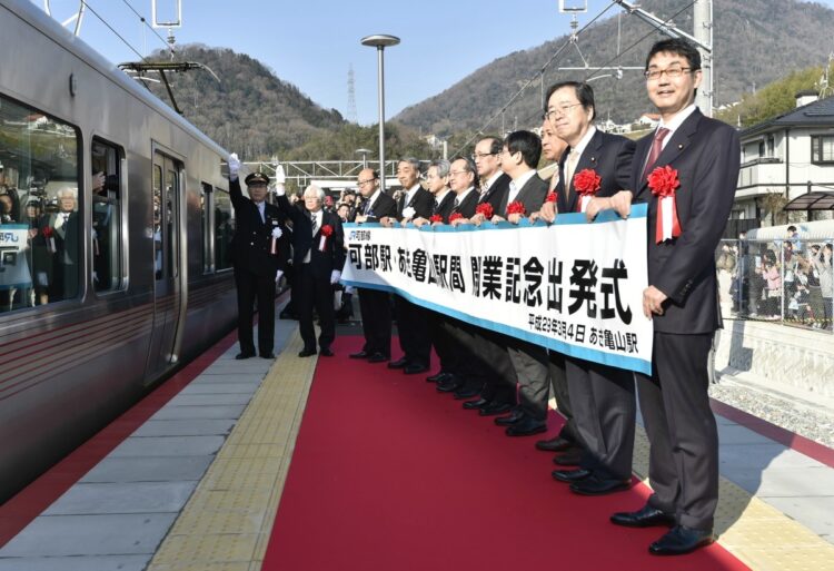 2017年3月4日、JR可部線延伸区間の新駅「あき亀山駅」で行われた出発式。左端から出発合図を出す貞本鉄富駅長ら（時事通信フォト）