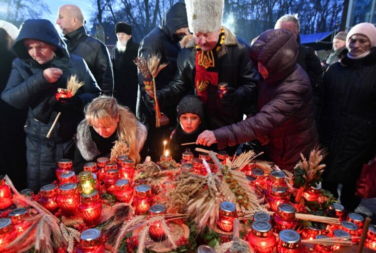 2018年1月、キエフにあるホロドモール（人工的大飢饉）犠牲者の慰霊碑にろうそくと小麦を捧げる（AFP＝時事）