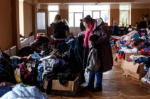 ウクライナ西部の町で支援物資の衣類を手にする女性(共同通信社)